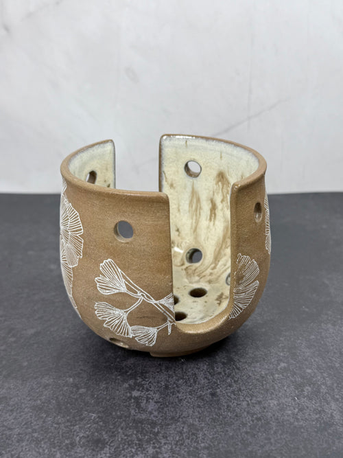 Ceramic sponge holder with floral patterns on a gray surface